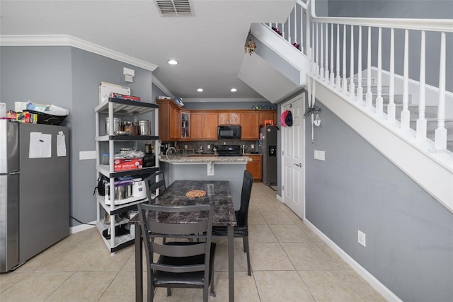 kitchen with light tile patterned flooring, tasteful backsplash, light stone counters, and black appliances