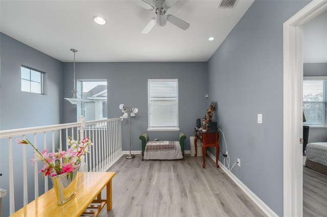 sitting room with ceiling fan, a healthy amount of sunlight, and light wood-type flooring