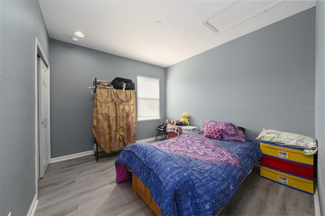 bedroom with hardwood / wood-style floors and a closet