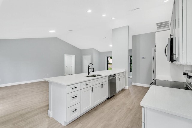 kitchen featuring white cabinetry, sink, a center island, vaulted ceiling, and appliances with stainless steel finishes