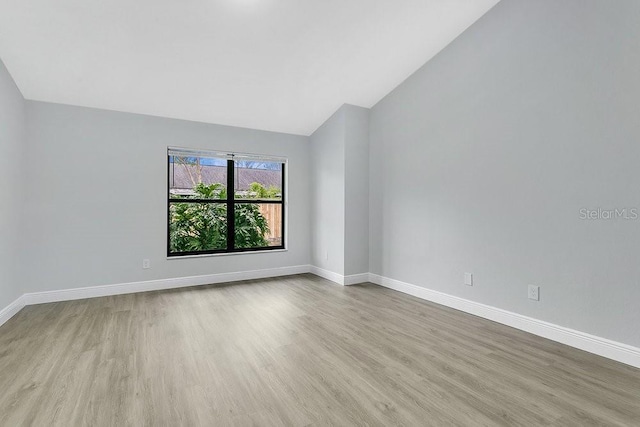 empty room featuring light hardwood / wood-style flooring and lofted ceiling