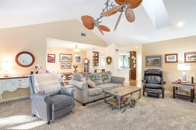 carpeted living room featuring ceiling fan with notable chandelier and high vaulted ceiling