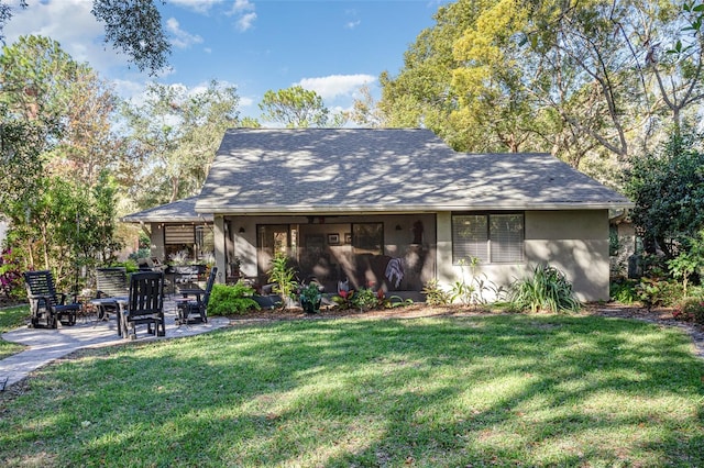 rear view of property with a lawn and a patio area