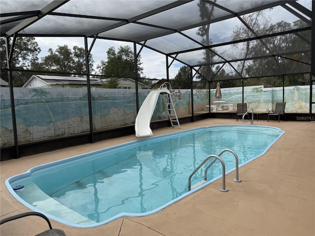 view of swimming pool featuring a patio, a lanai, and a water slide