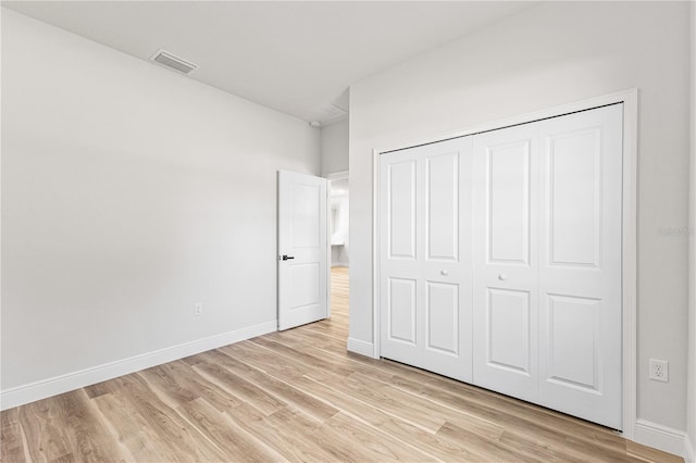 unfurnished bedroom with light hardwood / wood-style floors and a closet