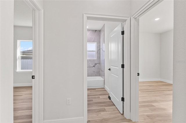 hall with plenty of natural light and light hardwood / wood-style floors