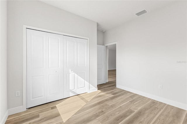 unfurnished bedroom featuring a closet and light wood-type flooring