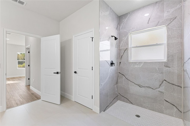 bathroom featuring tile patterned floors and a tile shower