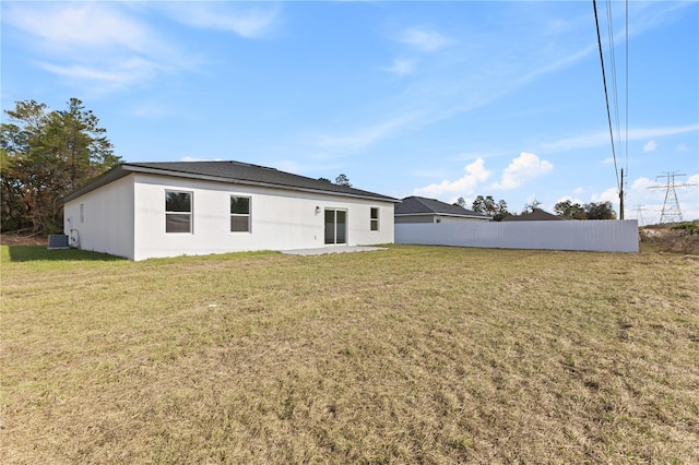 rear view of property with a yard and central air condition unit