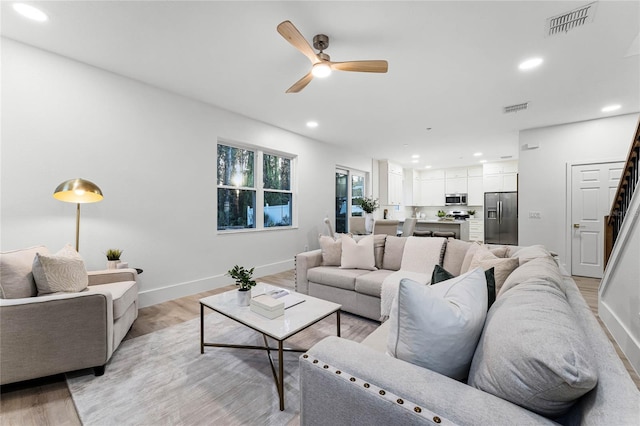 living room with ceiling fan and light hardwood / wood-style flooring