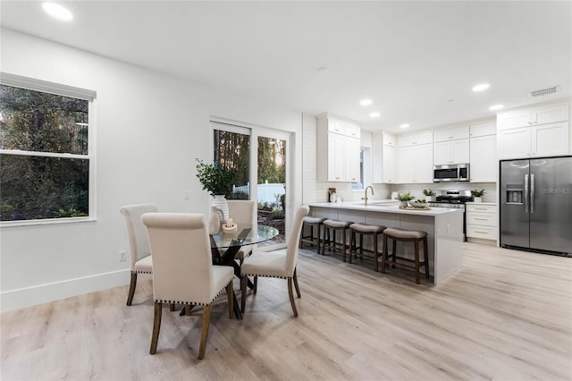 dining room with sink and light hardwood / wood-style flooring