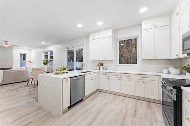 kitchen featuring stainless steel dishwasher, black electric range oven, and white cabinets