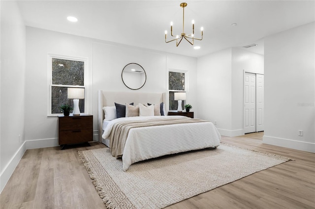 bedroom featuring a notable chandelier, light hardwood / wood-style flooring, and a closet