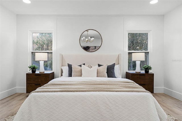 bedroom featuring a chandelier and light hardwood / wood-style flooring