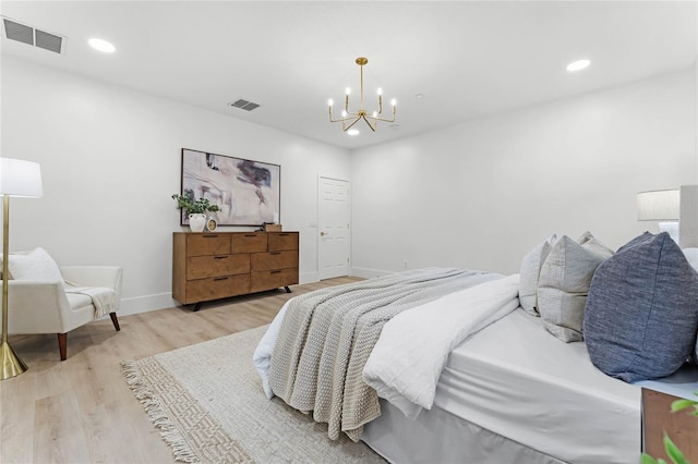 bedroom featuring an inviting chandelier and light wood-type flooring