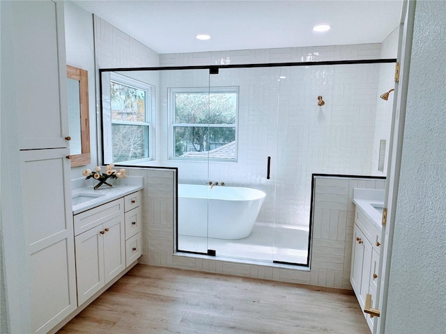 bathroom with vanity, hardwood / wood-style flooring, and separate shower and tub