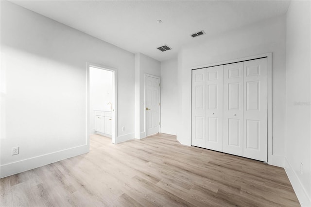 unfurnished bedroom with light hardwood / wood-style floors and a closet