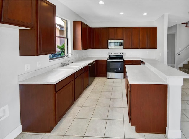 kitchen featuring light tile patterned flooring, stainless steel appliances, and sink