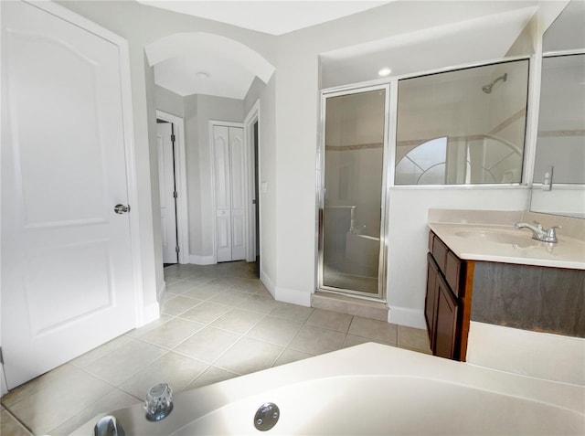 bathroom featuring vanity, tile patterned floors, and walk in shower