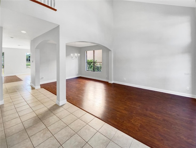 unfurnished living room with an inviting chandelier and light wood-type flooring