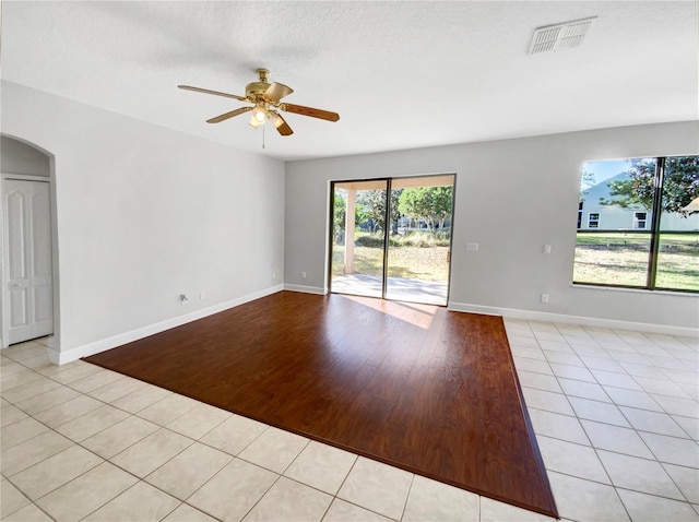 spare room with ceiling fan, a textured ceiling, and light wood-type flooring