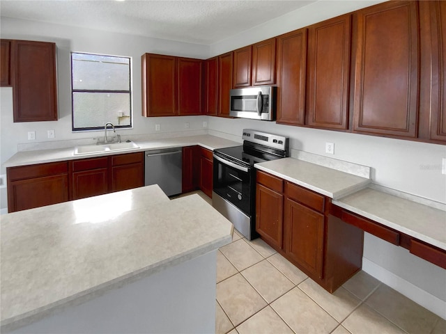 kitchen featuring sink, light tile patterned floors, stainless steel appliances, and a textured ceiling