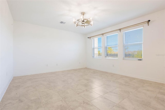 tiled empty room with an inviting chandelier