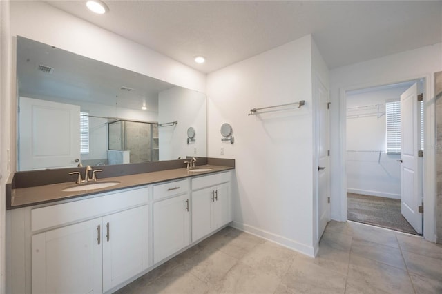 bathroom featuring tile patterned floors, vanity, and a shower with door