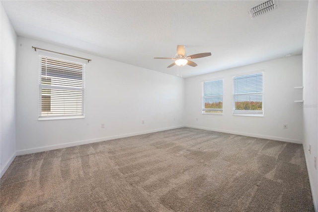 carpeted empty room featuring plenty of natural light and ceiling fan