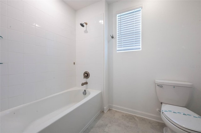 bathroom featuring toilet and tiled shower / bath