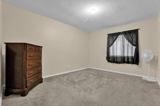 unfurnished bedroom featuring light colored carpet and a textured ceiling