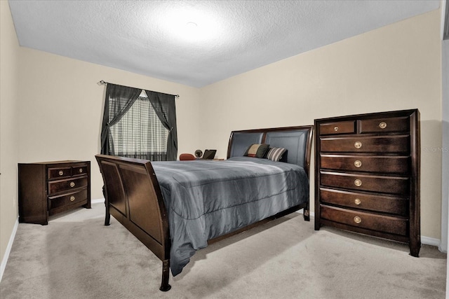 bedroom featuring light colored carpet and a textured ceiling