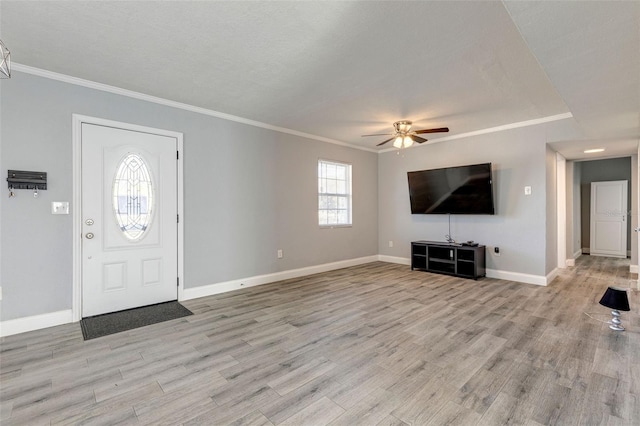 foyer entrance featuring a textured ceiling, light wood-type flooring, ceiling fan, and ornamental molding