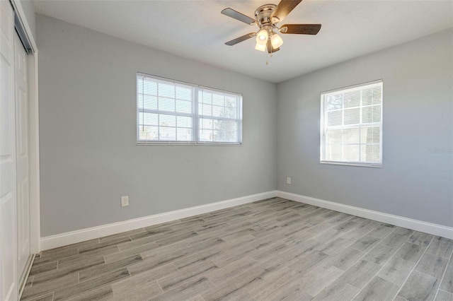 unfurnished room with a wealth of natural light, ceiling fan, and light hardwood / wood-style floors