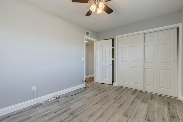 unfurnished bedroom with ceiling fan, light hardwood / wood-style floors, and a closet