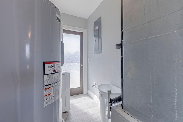 bathroom featuring hardwood / wood-style flooring, electric panel, and water heater