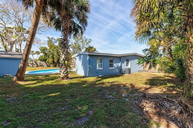 rear view of property with a yard and central AC