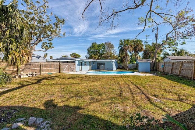 view of yard featuring a fenced in pool and a storage shed