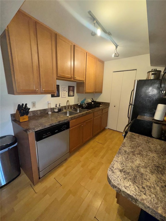 kitchen with sink, rail lighting, stainless steel appliances, and light wood-type flooring