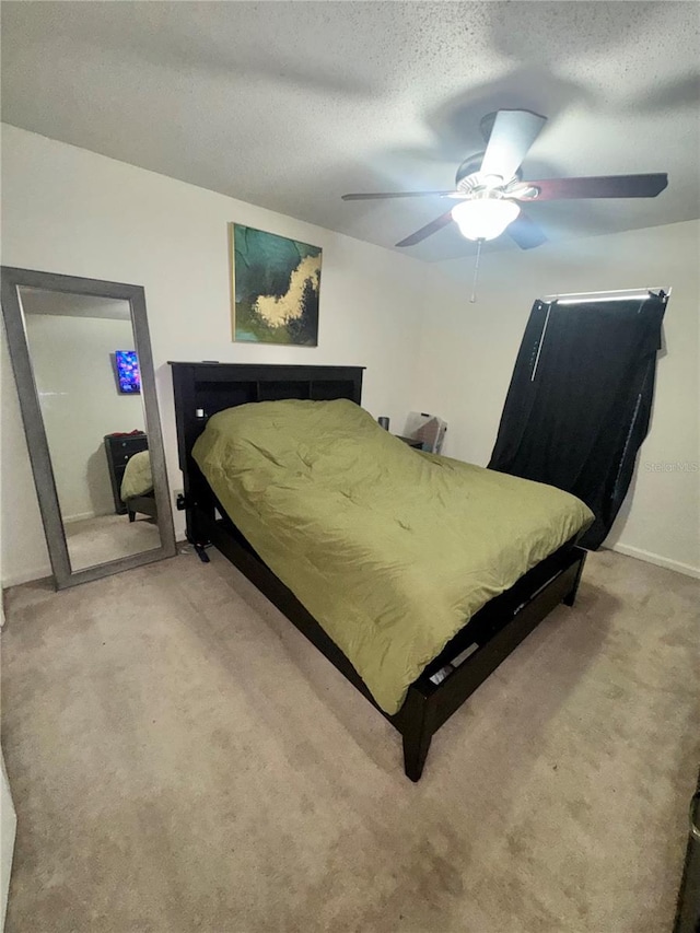 bedroom featuring carpet flooring, a textured ceiling, and ceiling fan