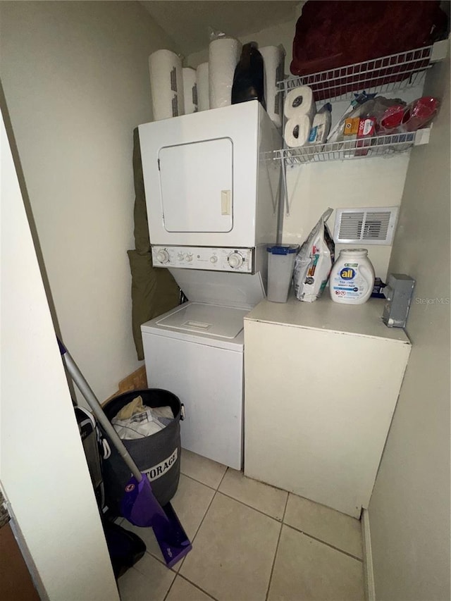 washroom with light tile patterned floors and stacked washer and dryer