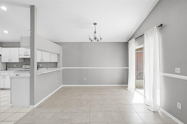 unfurnished dining area featuring lofted ceiling, sink, light tile patterned floors, and a chandelier