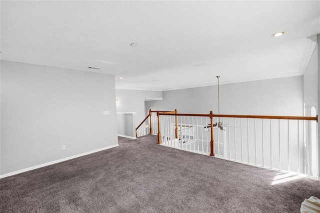 carpeted spare room featuring a textured ceiling and crown molding