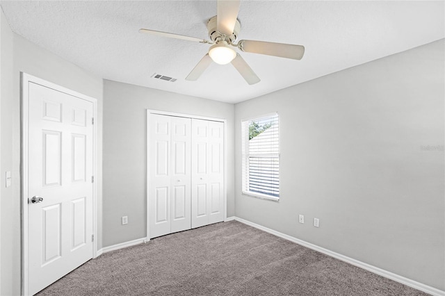 unfurnished bedroom featuring ceiling fan, a closet, carpet, and a textured ceiling