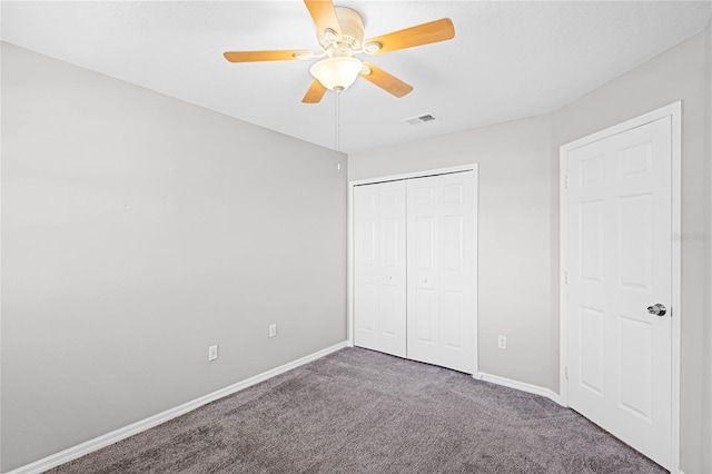 unfurnished bedroom featuring a closet, dark carpet, and ceiling fan