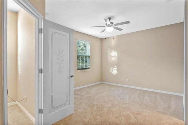 carpeted spare room with ceiling fan