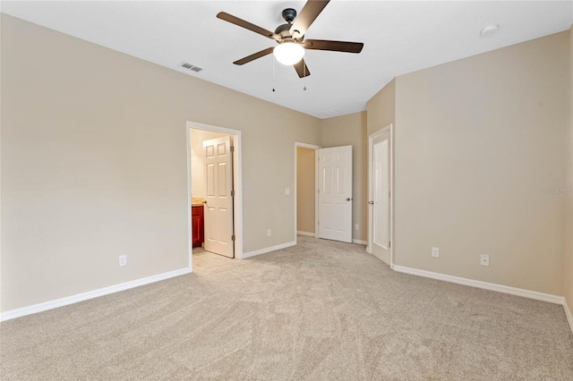 unfurnished bedroom featuring connected bathroom, ceiling fan, and light colored carpet