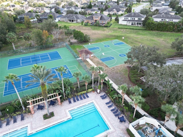 view of pool featuring basketball hoop and tennis court