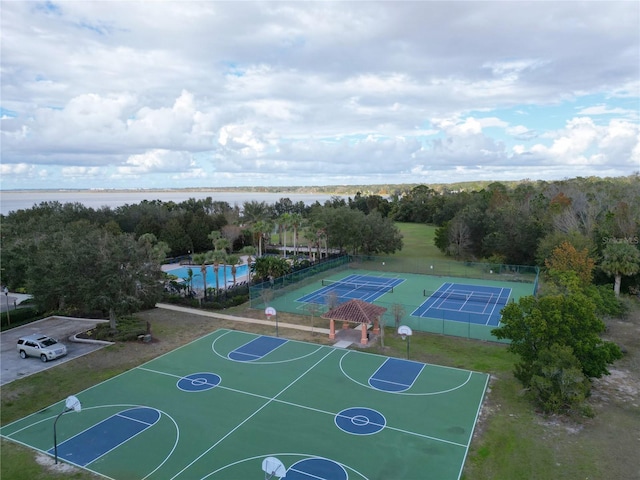 view of basketball court featuring tennis court and a water view