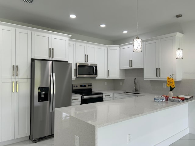 kitchen with stainless steel appliances, white cabinetry, sink, and decorative light fixtures